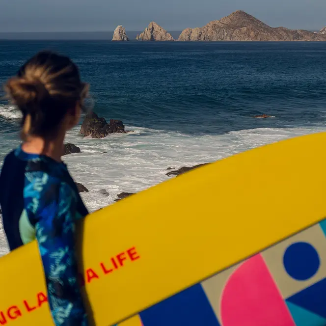 Woman with a surfboard under her arm