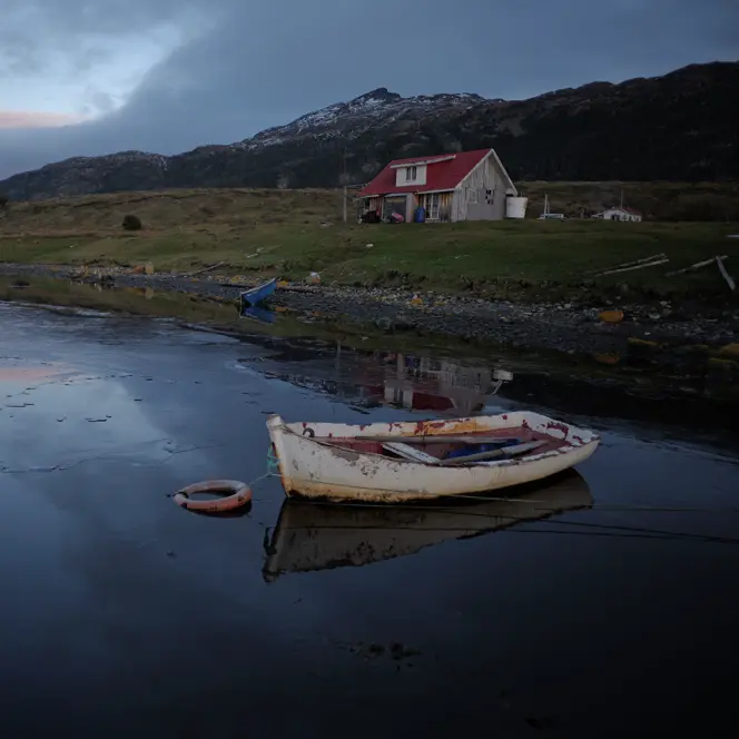 lonely house by the lake with an old boat
