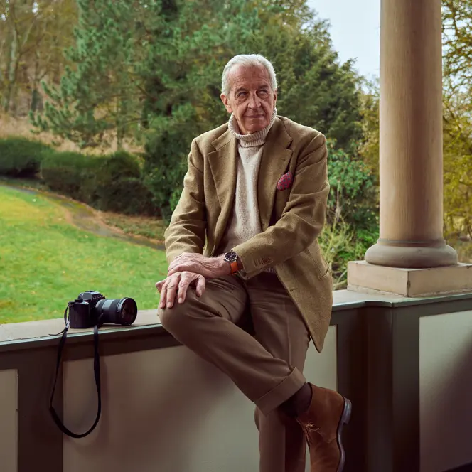 John Golberger is sitting on a veranda with a Leica beside him and a Leica ZM 12 on his wrist