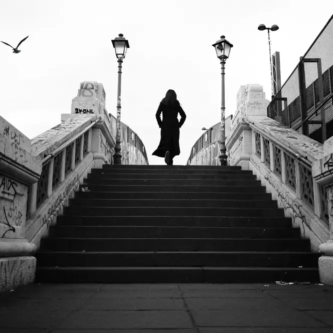 black-and-white photograph, woman running up a flight of stairs