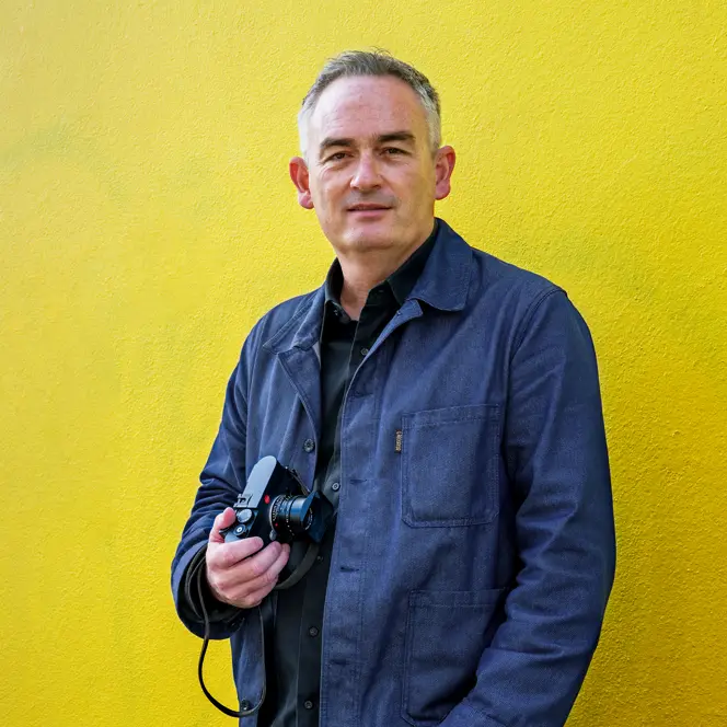 Jesse Marlow with a Leica M EV1 in front of a yellow wall