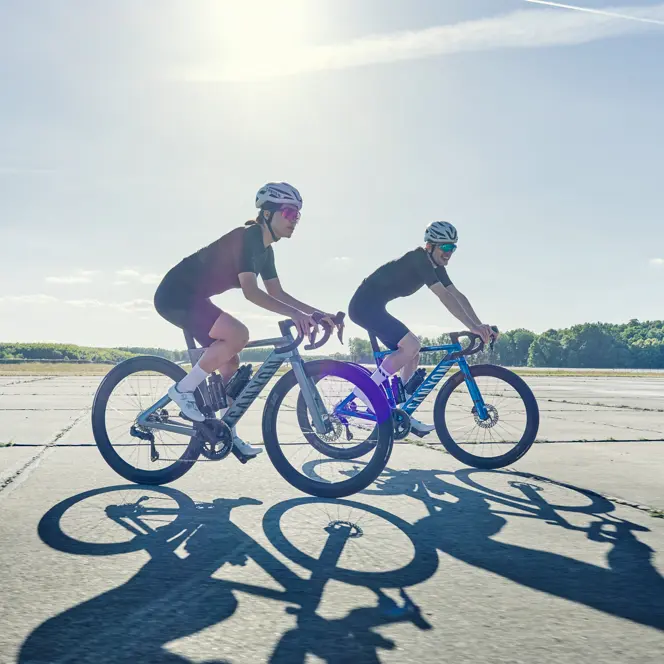 Zwei Rennradfahrer mit Canyon Fahrrädern auf Flugplatz Tino Pohlmann