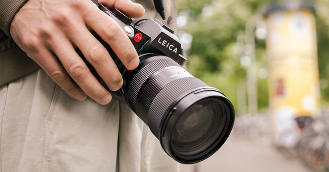 Man holding a Leica SL camera.