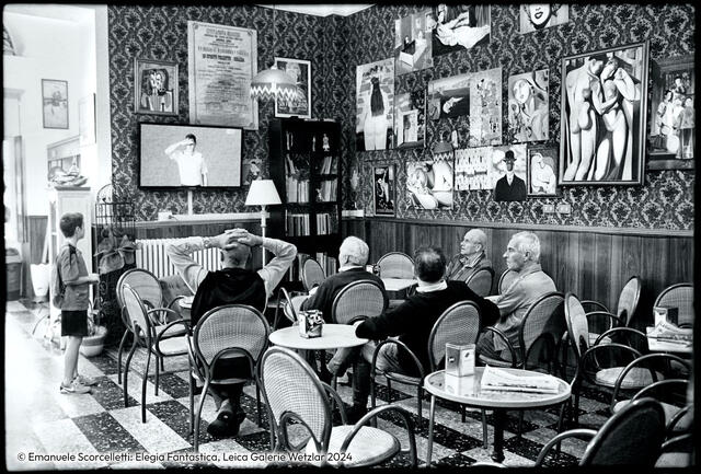 People sitting in a bar watching television