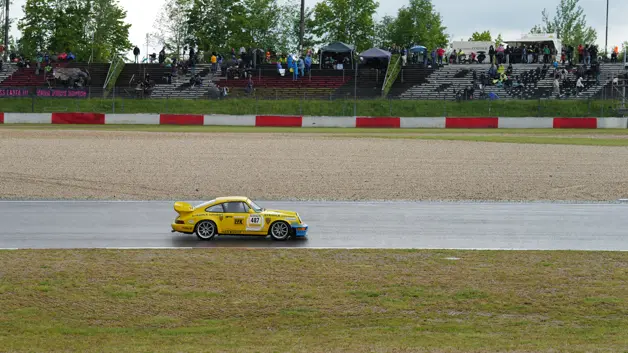 Old yellow Porsche on the race track