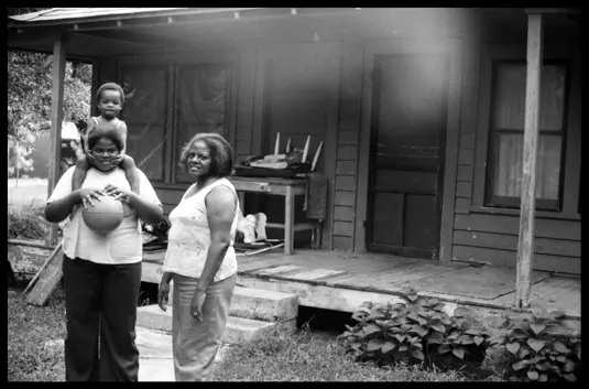 Phyllis with her mother and nephew outside the family home in Arkansas. Analog documentary photograph from Lisa McCord’s multi-generational series “Rotan Switch.”