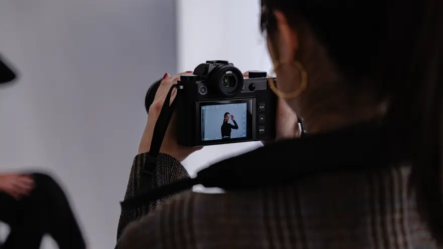 Femme prenant en photo un modèle avec un boîtier SL3 dans les mains