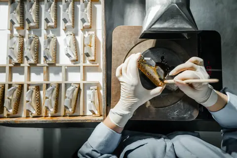 A worker making parts for the Leica binoculars