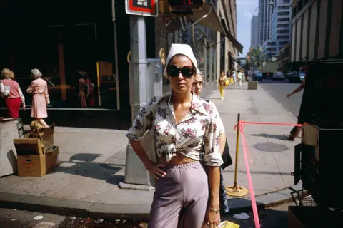 Woman with big sunglasses and hand on her hip posing on the street