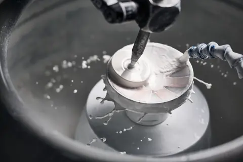A Leica employee polishes lenses of a Leica spotting scope