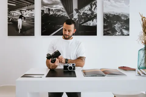 Leica camera salesperson displays Leica cameras