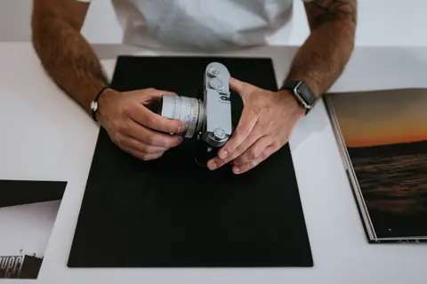 Leica camera salesperson displays Leica cameras