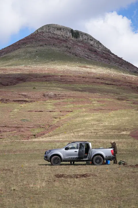 A car parking in front of a mountain