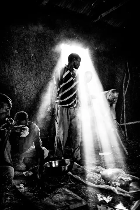 man standing in a strong light black and white