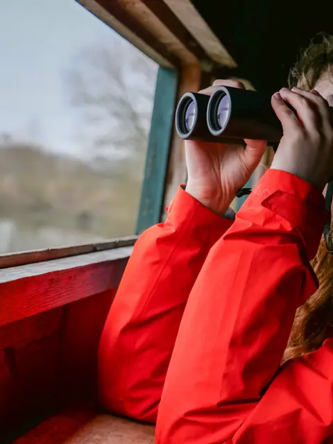 Birder looking through her binoculars