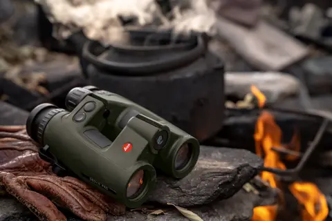 Leica Geovid Pro 42 olive green beside a campfire.