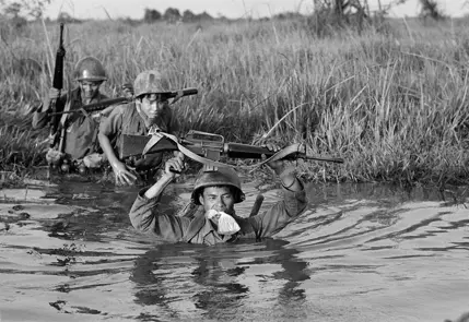 soldiers walking through a river b&w