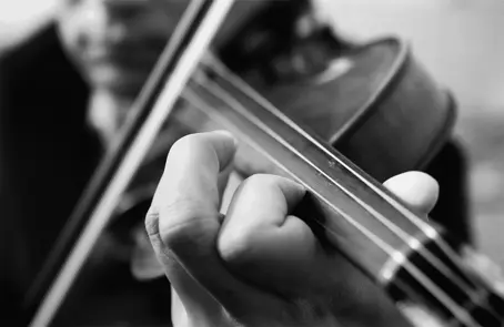 Close-up black-and-white photograph of a violinist