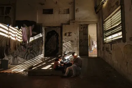 Children gathered in a sunlit abandoned building, capturing everyday life, community, and resilience in an urban setting.
