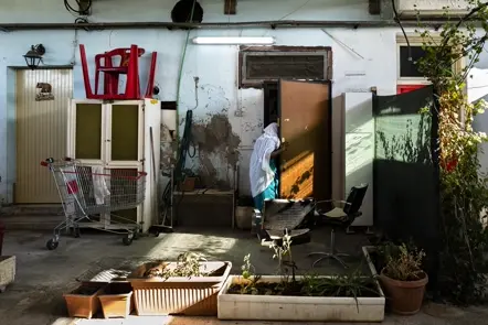 Resident entering a modest courtyard home, documenting daily routines, domestic spaces, and urban living conditions.
