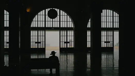 Homme avec un chapeau attendant dans le hall d'une gare