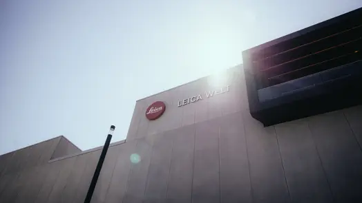 Leica Welt building beneath a bright blue sky.