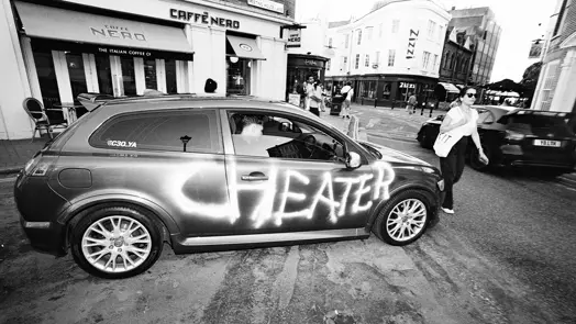 Black and White photo of a car with the word cheater painted on the side.