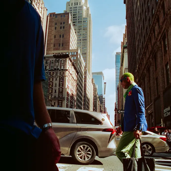 Man with green hair crosses the street