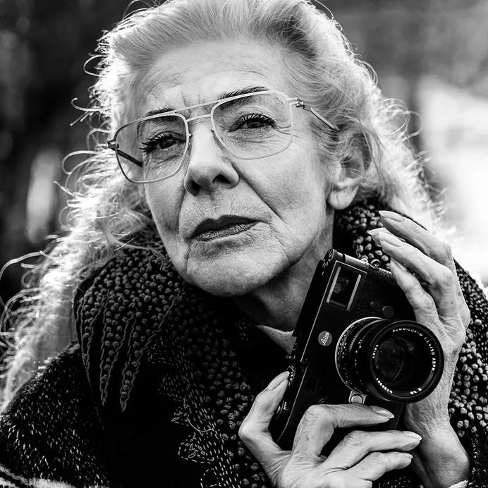 Woman with glasses and a camera in her hand