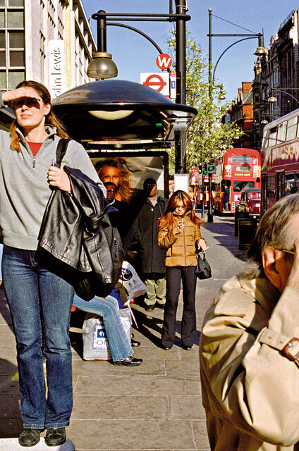 A woman who was standing on a bench, appearing to be looking for something and other people