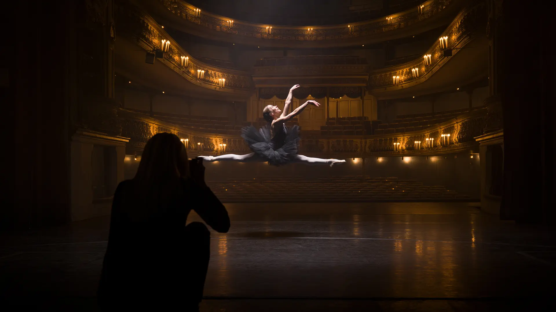 Person taking a picture of a jumping Ballerina in the theater