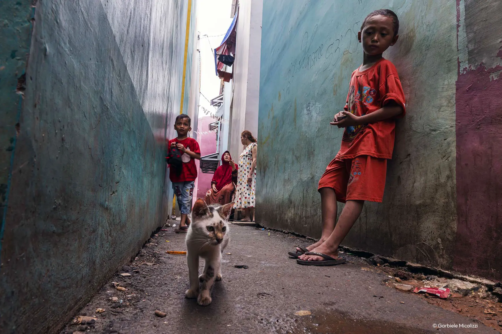 Children and cat standing between skyscrapers