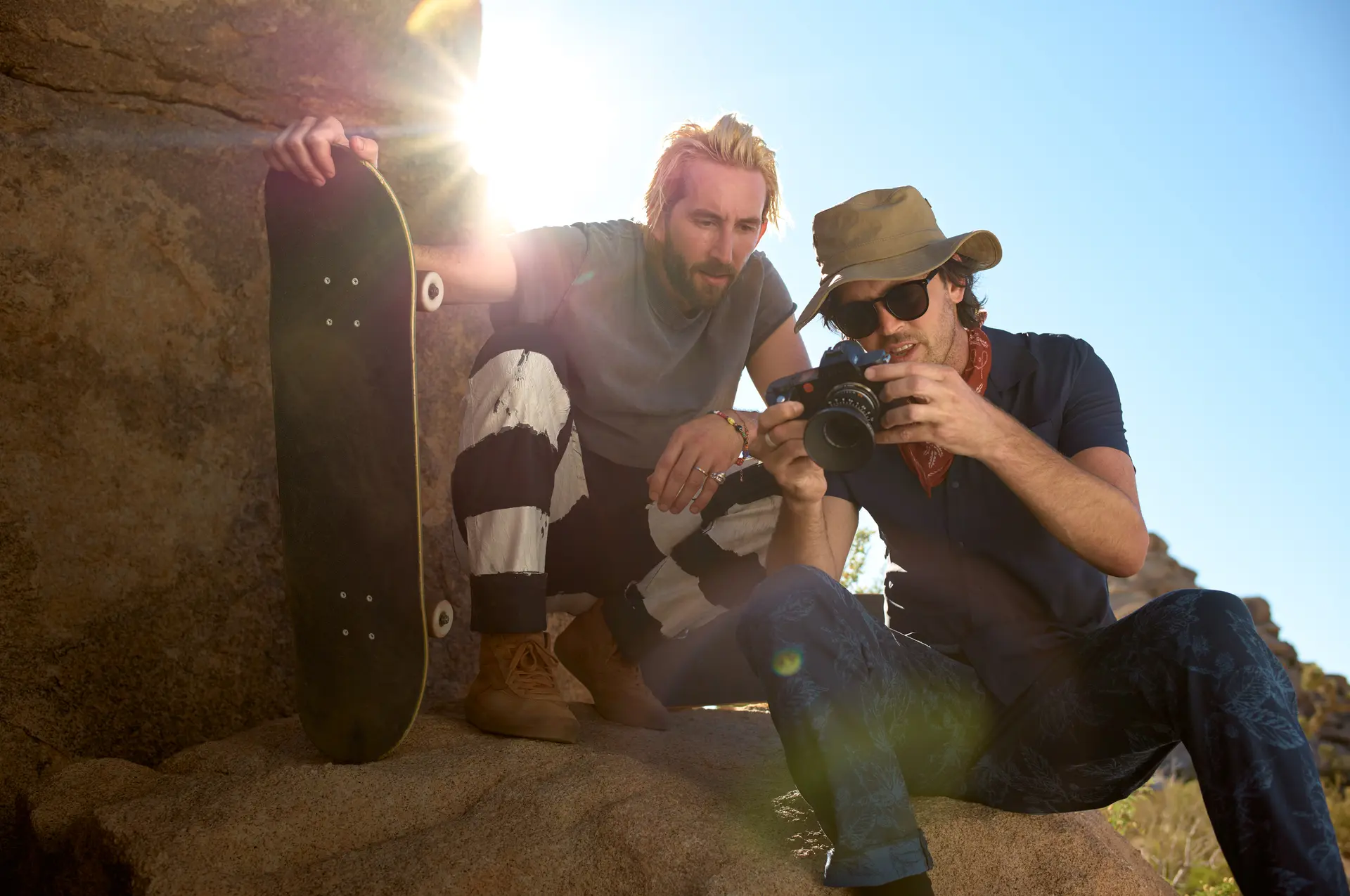Hill brothers view pictures on the camera in the desert