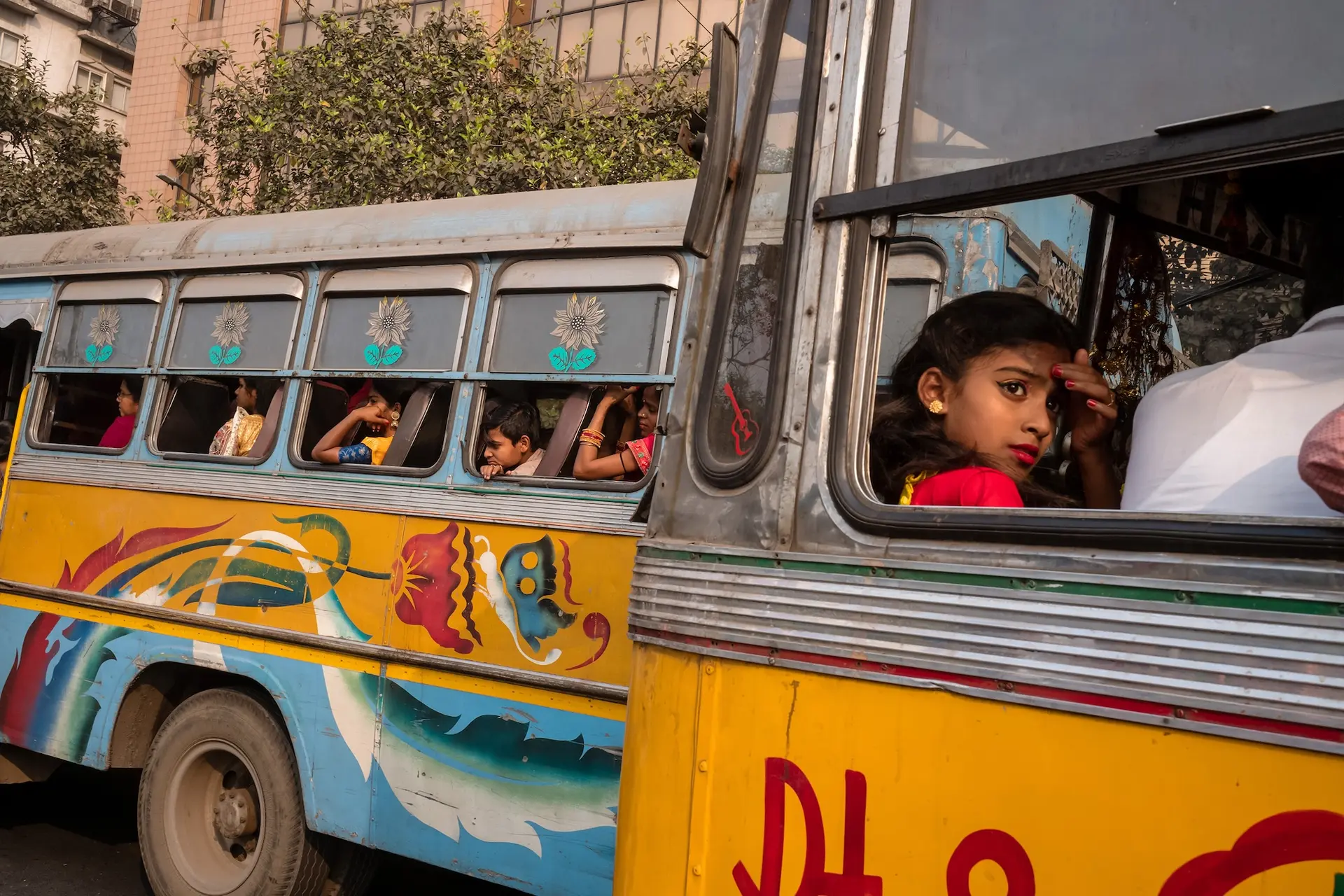 Girl sits in a colorfully painted bus