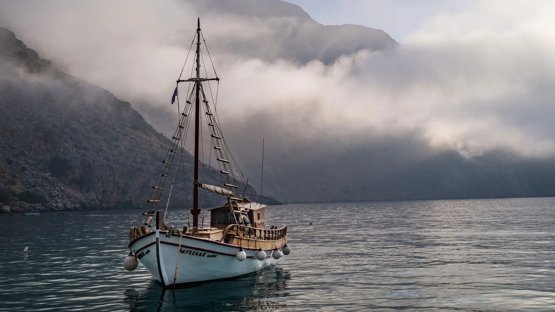 A sailing ship on the sea in front of an island