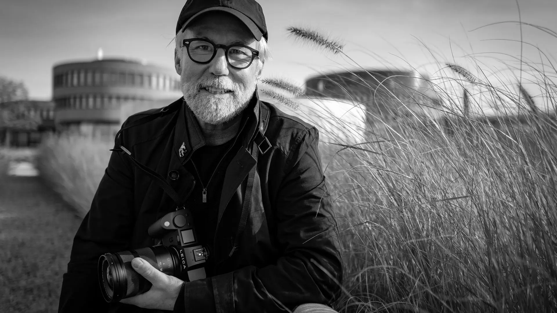 Portrait of photographer Ragnar Axelsson holding a Leica camera