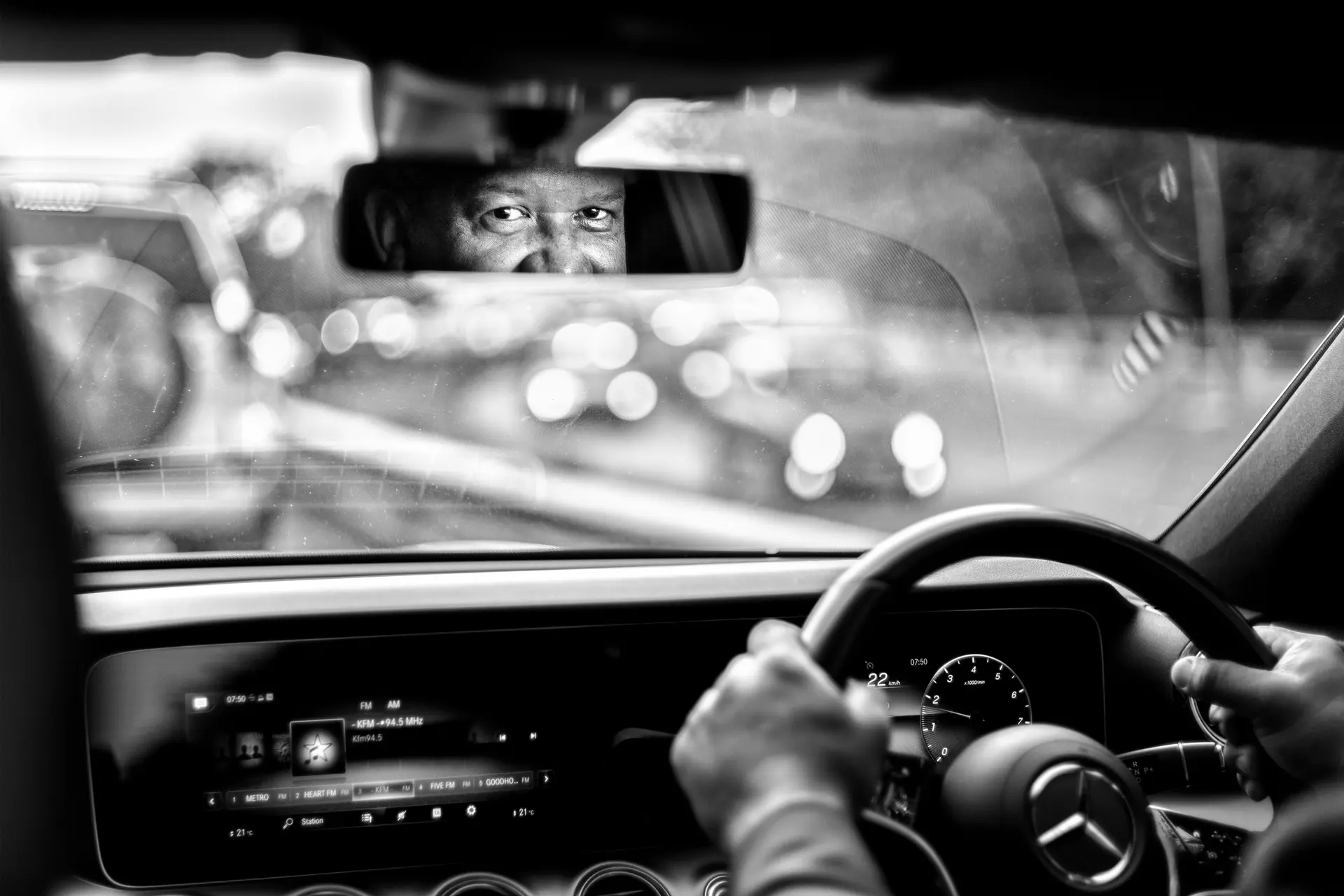 Photo of a car driver looking intently in the rear-view mirror