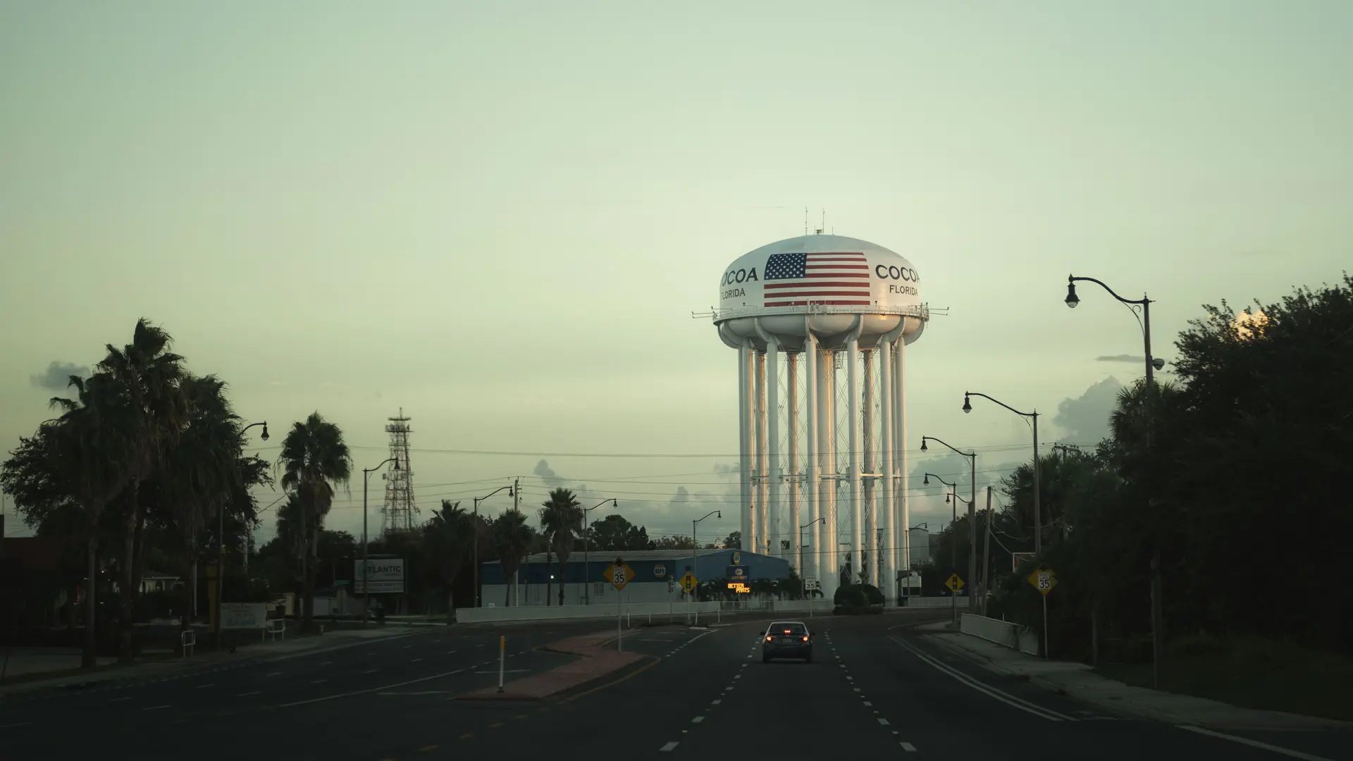 An empty road leads to a water tower labelled ‘Cocoa, Florida’.