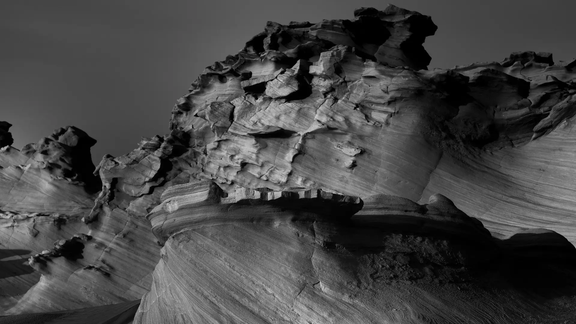 Black and white photography of jagged rock formations in a barren landscape