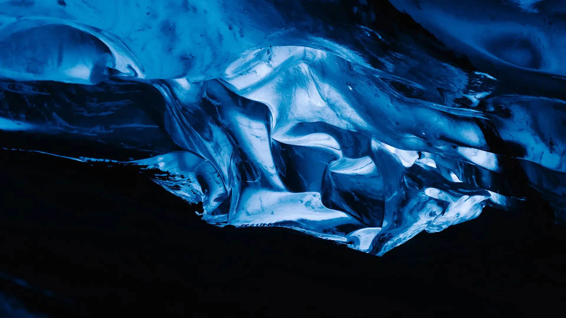 A glowing blue ice formation in a dark cave.