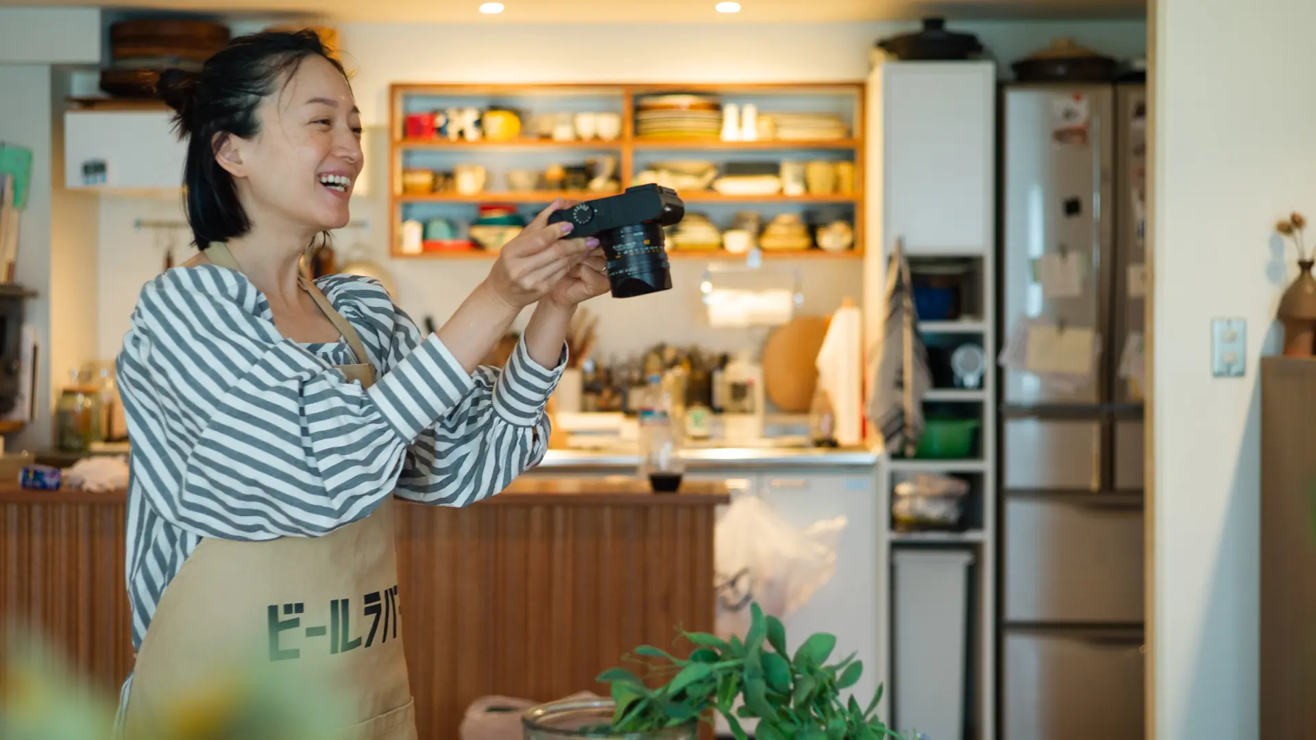 Smiling woman taking a picture of a plant in a food store.