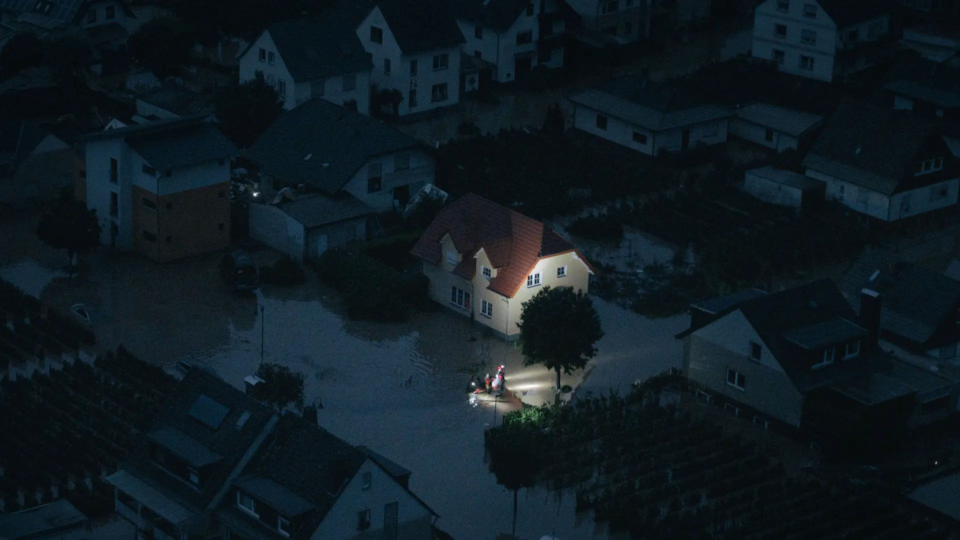 Night shot of a flooded city and rescue workers are in focus.