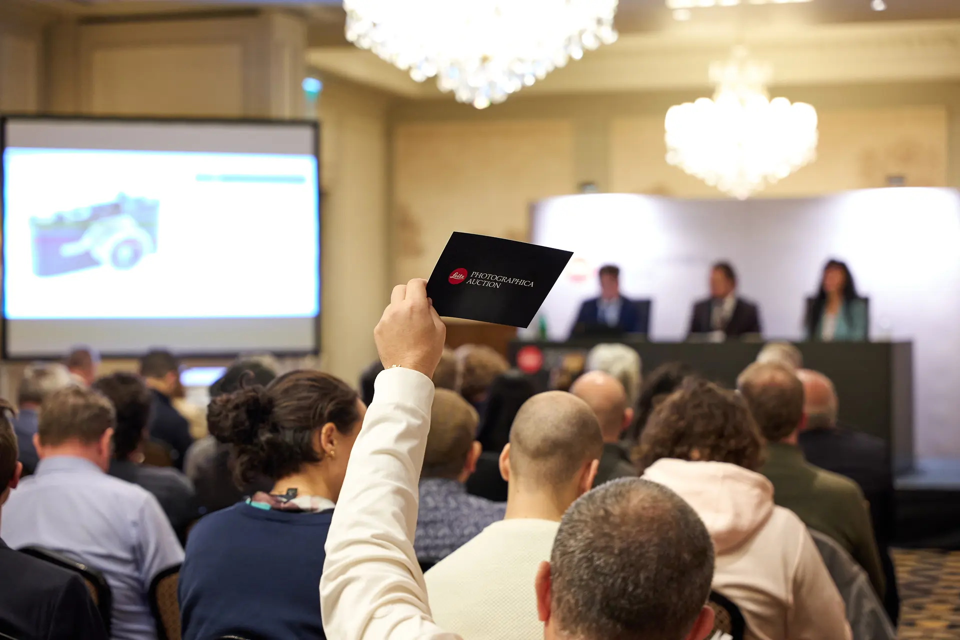 People on a Leitz Photographica Auction bidding.