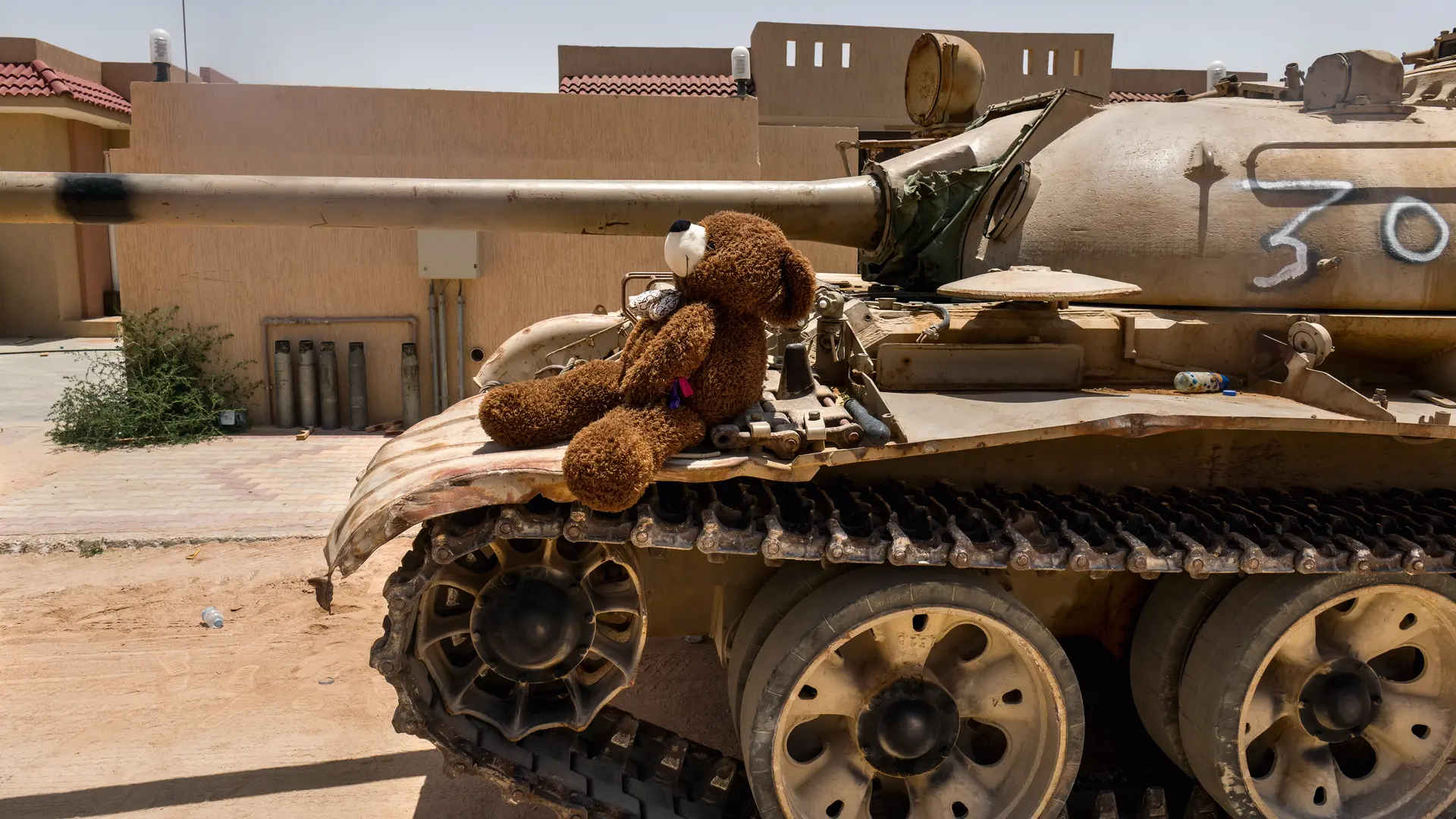 Teddy bear sitting on a tank