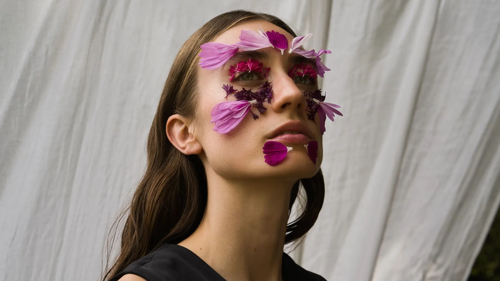 Ein Portrait einer Frau mit Blumen auf ihrem Gesicht.