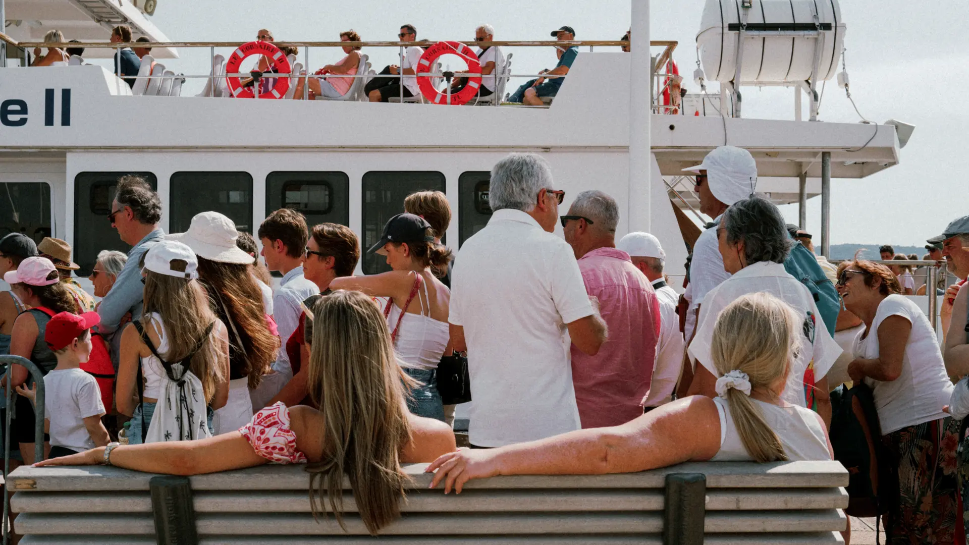 Photograph of tourists on a boat with two ladies sitting on a bench