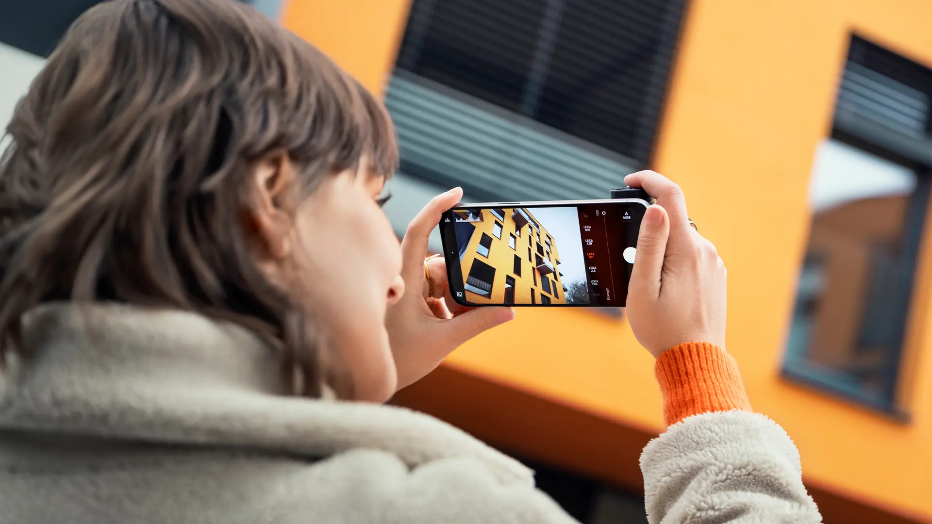 Woman photographing with the Leica LUX Grip