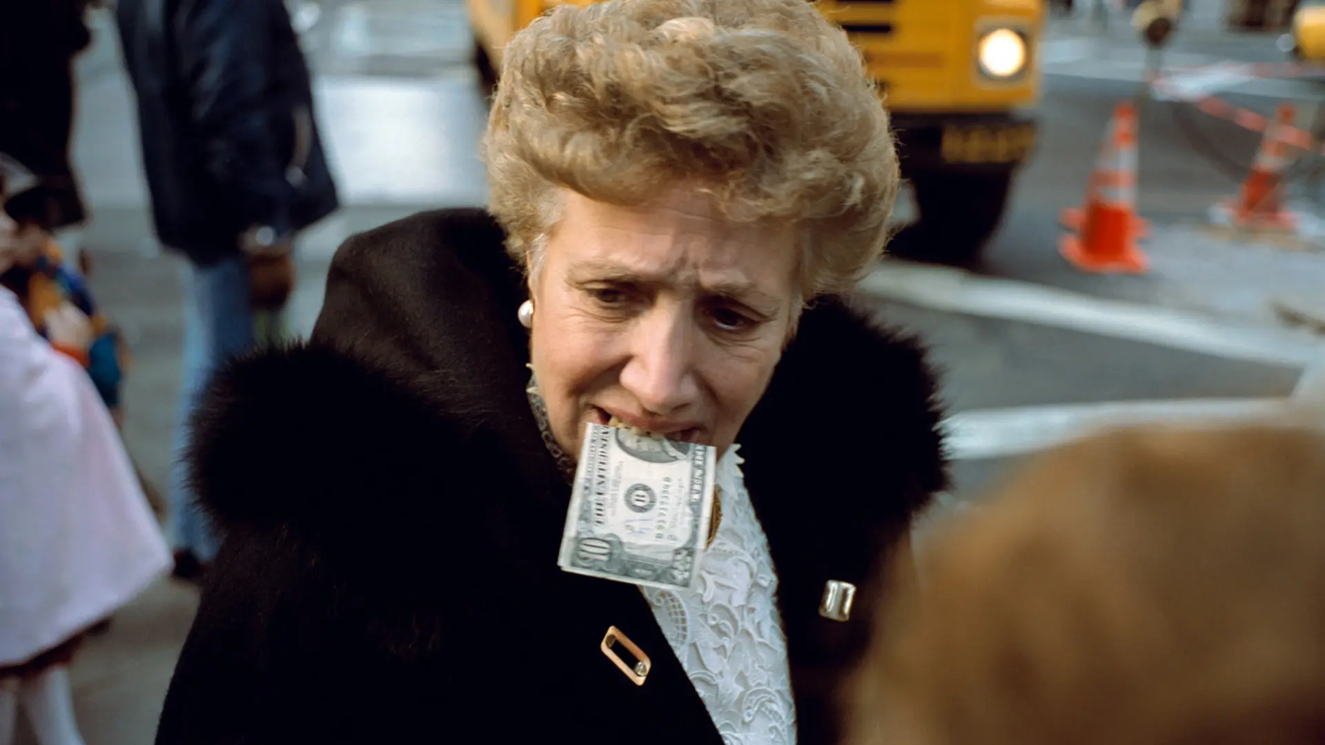 Woman with a dollar bill in her mouth