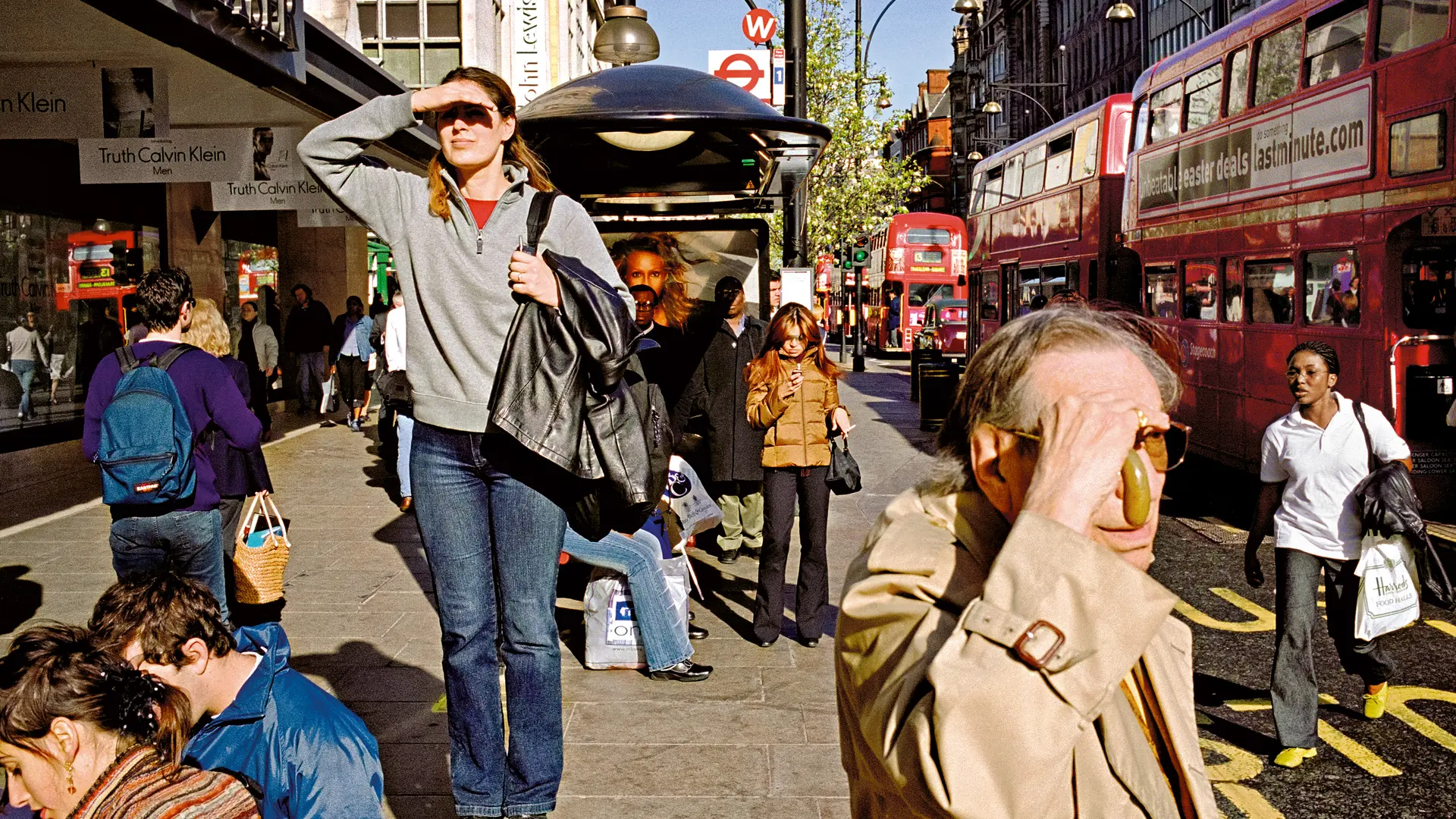 A woman who was standing on a bench, appearing to be looking for something and other people