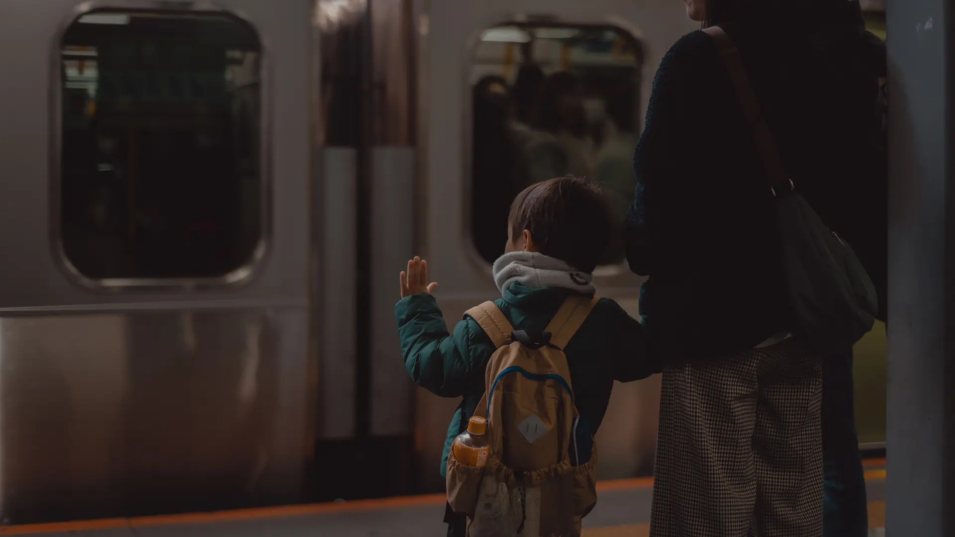 Mum and son standing at a subway stop